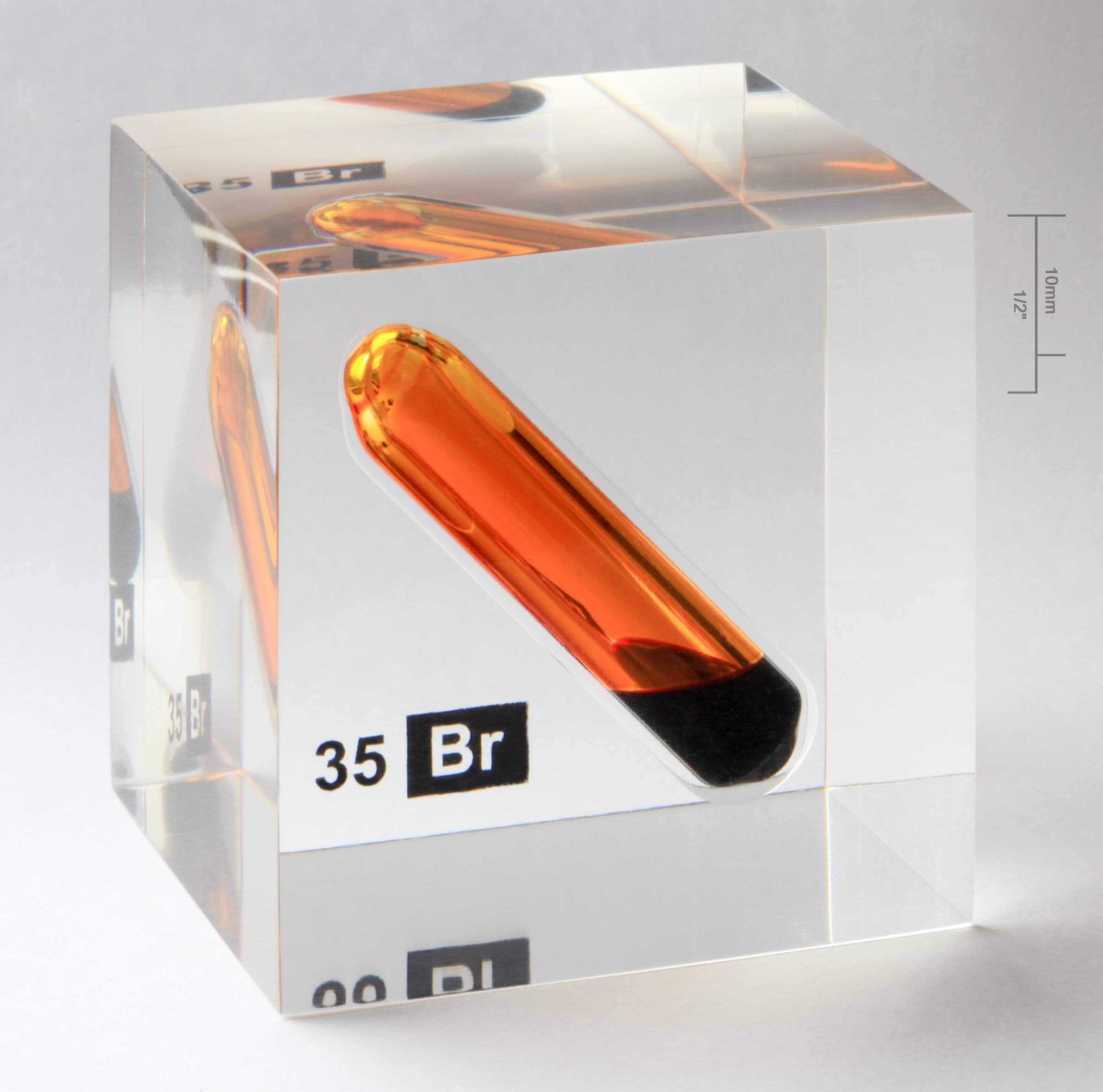 Sealed glass ampoule of amber bromine set in a clear acrylic cube